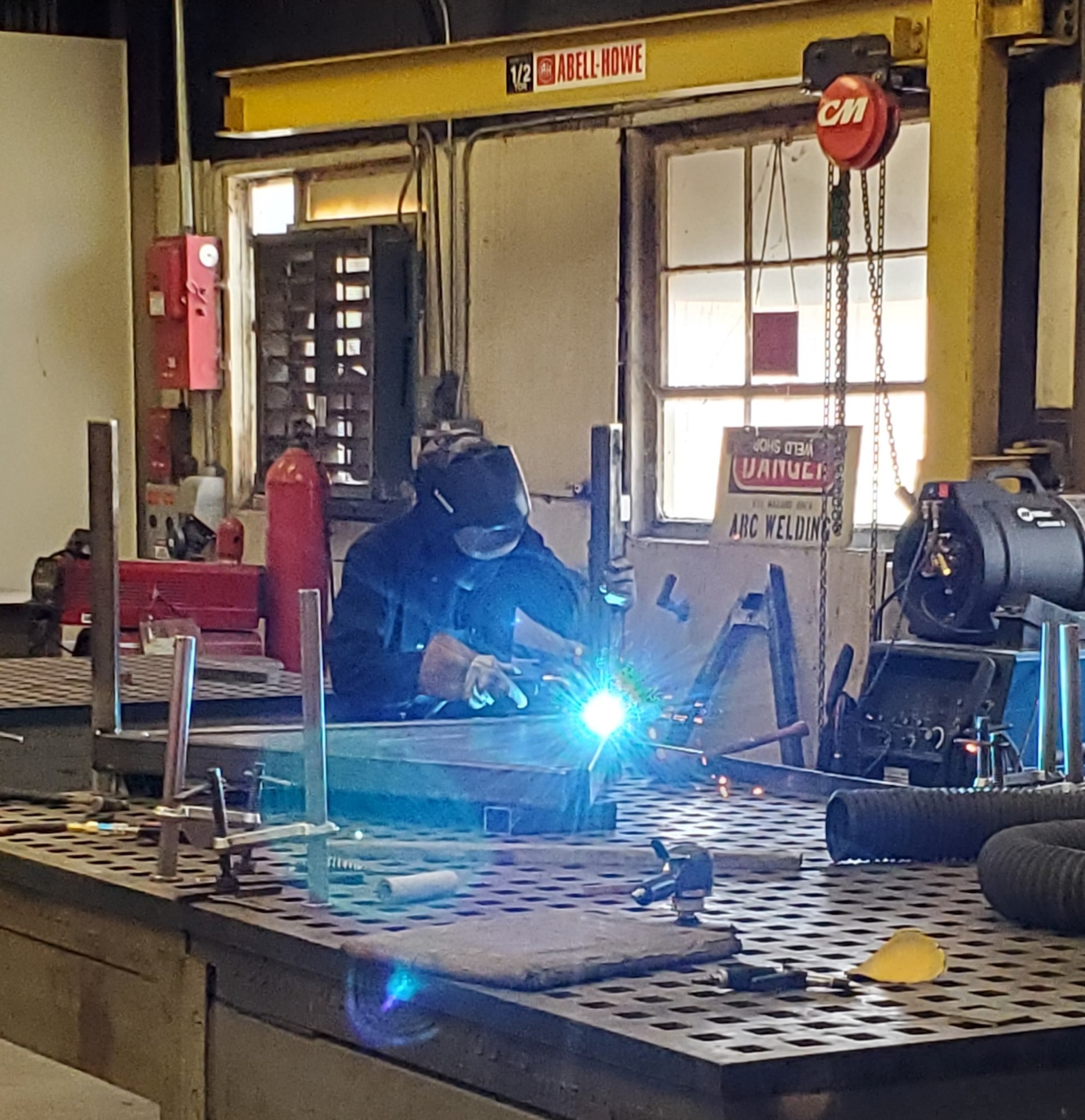 A man in welding gear is welding