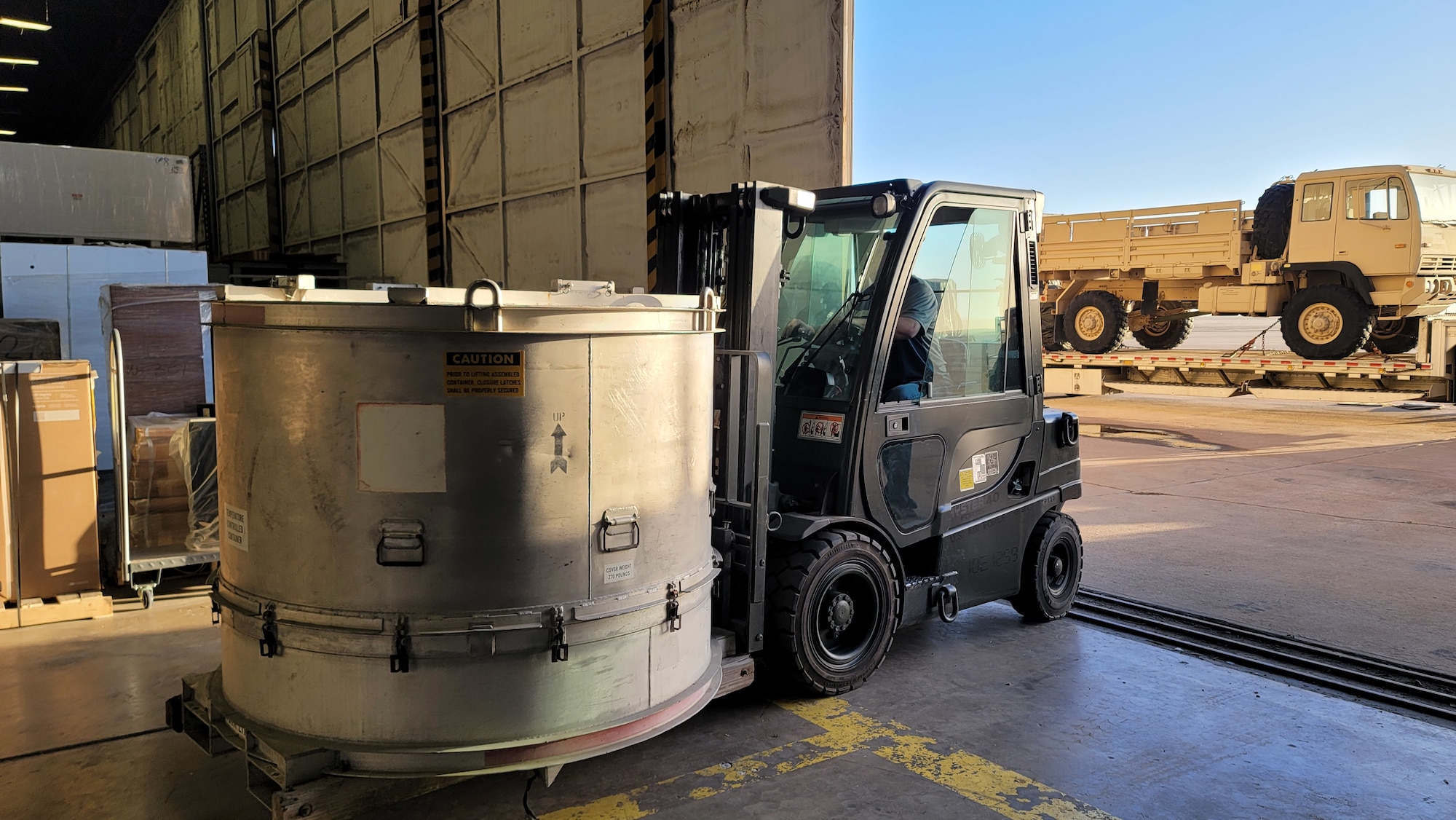 A cylindrical item is on a small forklift