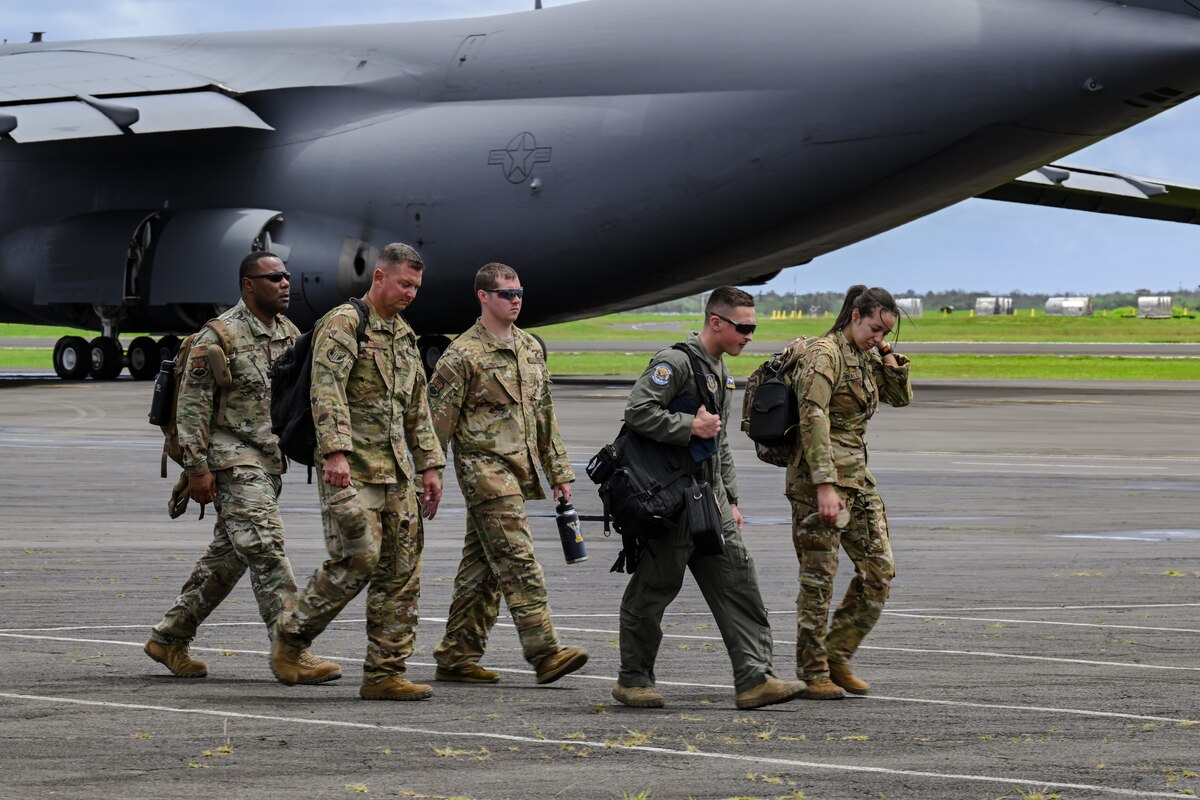 U.S. Air Force Reserve Citizen Airmen walk toward a C-130H Hercules aircraft.