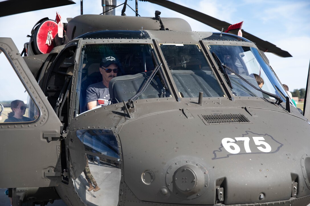 A man sits in the front of a UH-60 Black Hawk at the 2023 Frankfort Aviation Day in Frankfort, Kentucky, Sept. 16, 2023. The Frankfort Aviation Day showcases multiple air shows and partnerships between several local, county, and state Emergency Services and the Kentucky National Guard. (U.S. Army National Guard photo by Spc. Caleb Sooter)