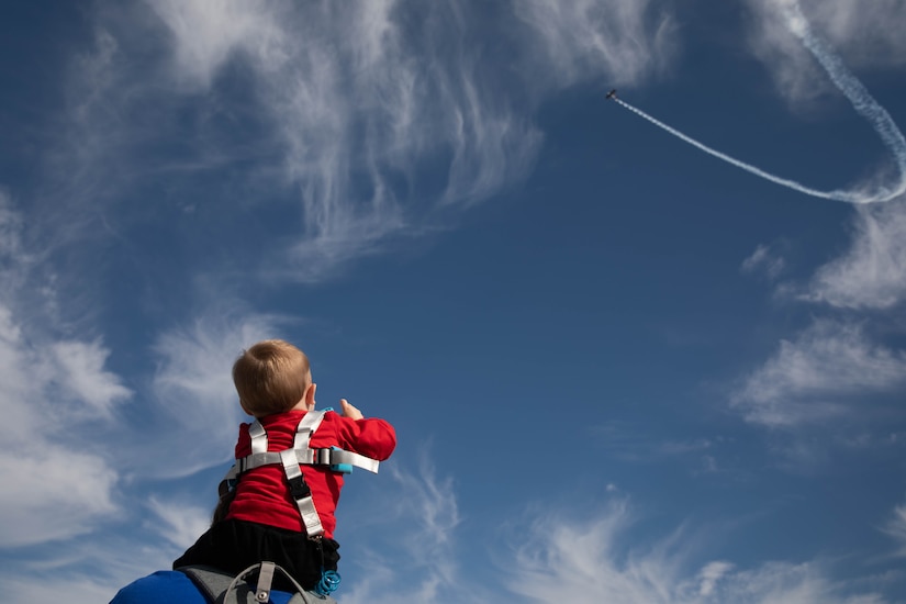 A child watches an air show at the 2023 Frankfort Aviation Day in Frankfort, Kentucky, Sept. 16, 2023. Pilots in the air show demonstrated a wide array of technical maneuvers in the sky. (U.S. Army National Guard photo by Spc. Caleb Sooter)