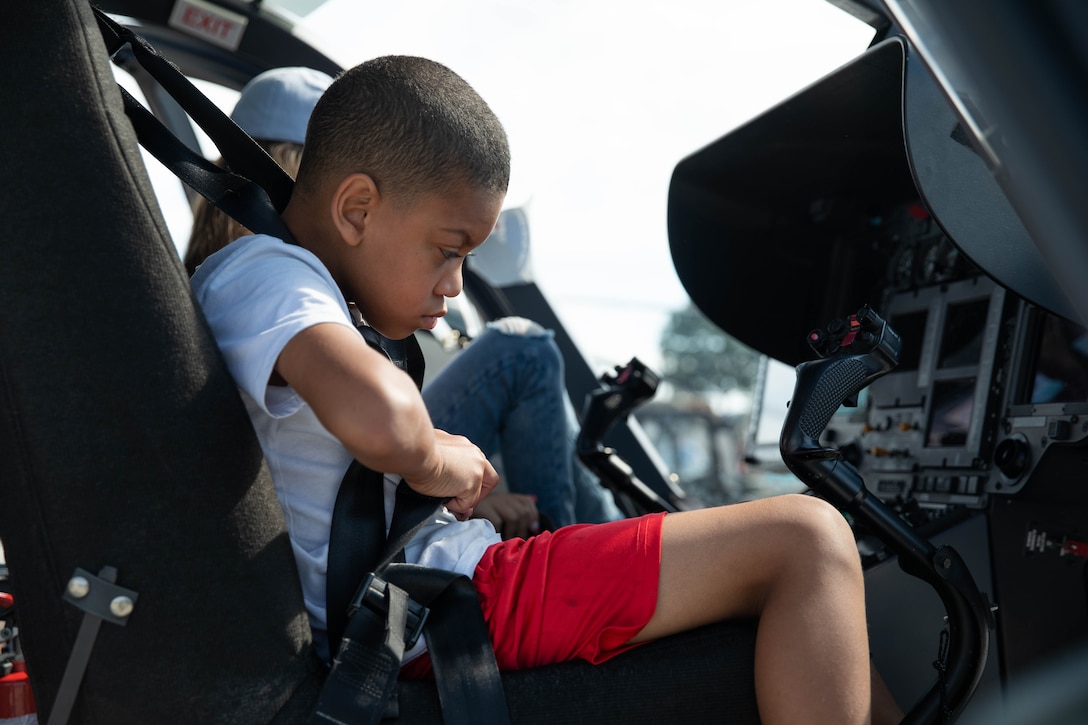 A child sits in the front of a UH-72 Lakota at the 2023 Frankfort Aviation day in Frankfort, Kentucky, Sept. 16, 2023. Visitors to the event had the opportunity to explore Kentucky Army National Guard Aviation assets in static displays. (U.S. Army National Guard photo by Spc. Caleb Sooter)
