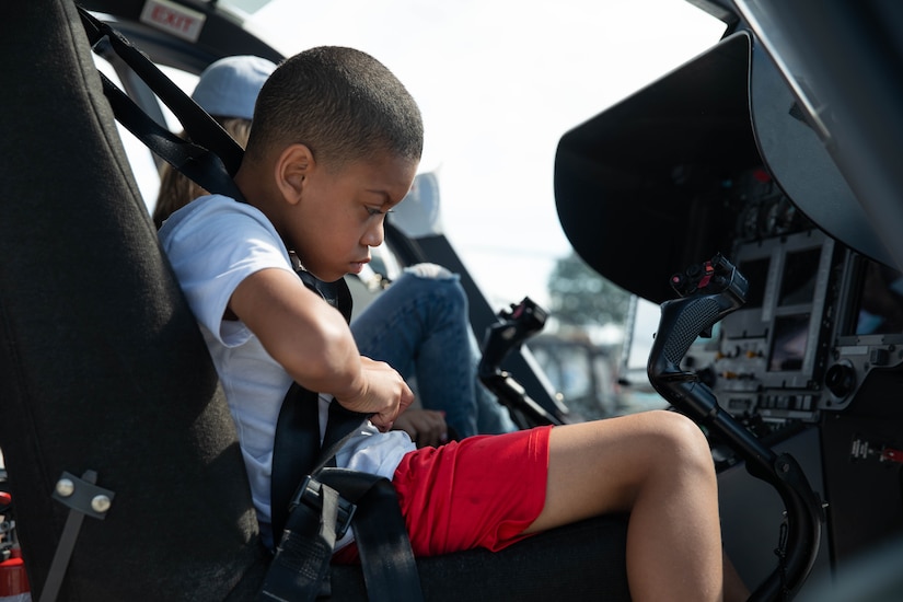 A child sits in the front of a UH-72 Lakota at the 2023 Frankfort Aviation day in Frankfort, Kentucky, Sept. 16, 2023. Visitors to the event had the opportunity to explore Kentucky Army National Guard Aviation assets in static displays. (U.S. Army National Guard photo by Spc. Caleb Sooter)