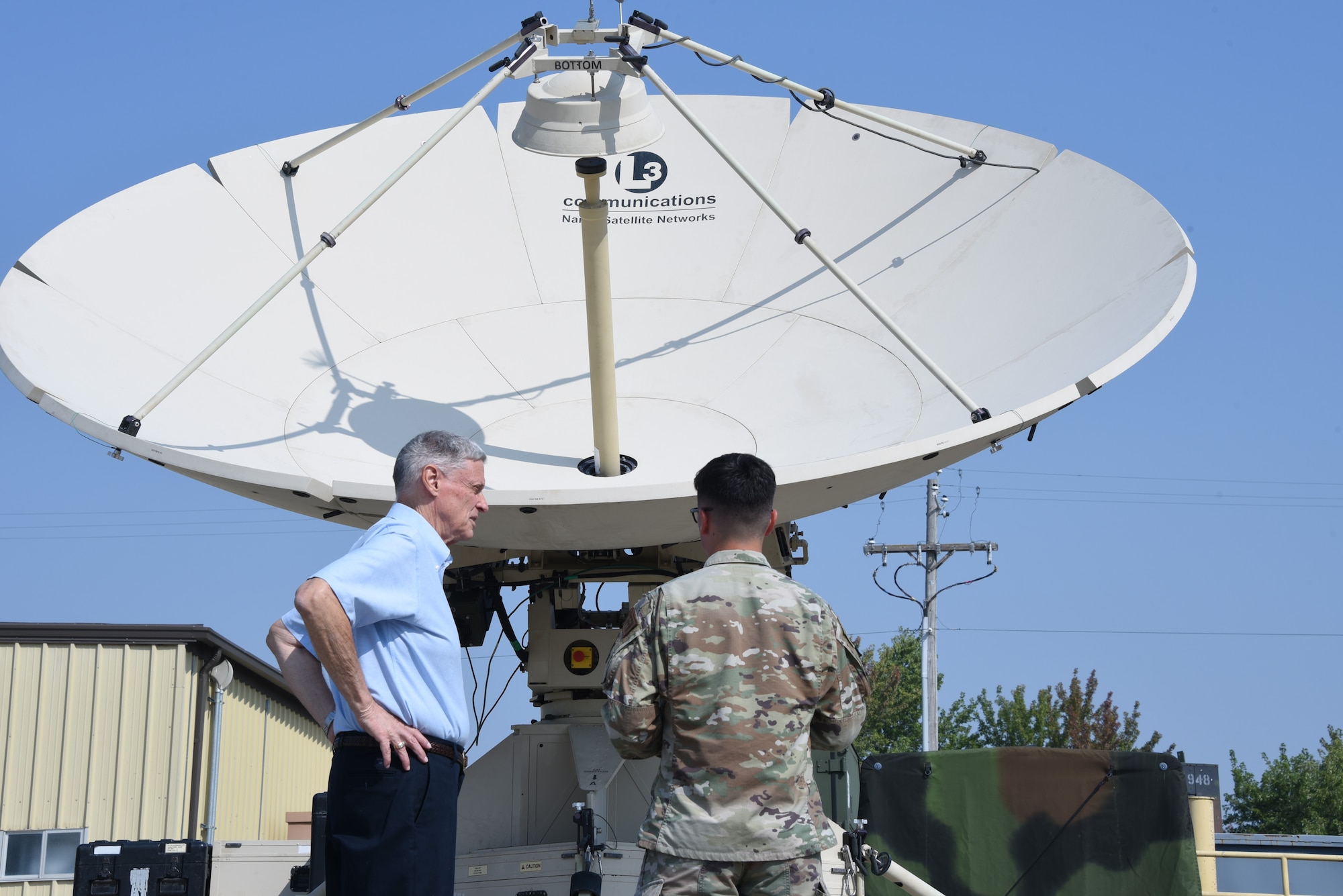 U.S. Air National Guard Airman of the 133rd Test Squadron shows visitors to the 133rd Test Squadron 75th Anniversary open house event a quad-band large aperture antenna