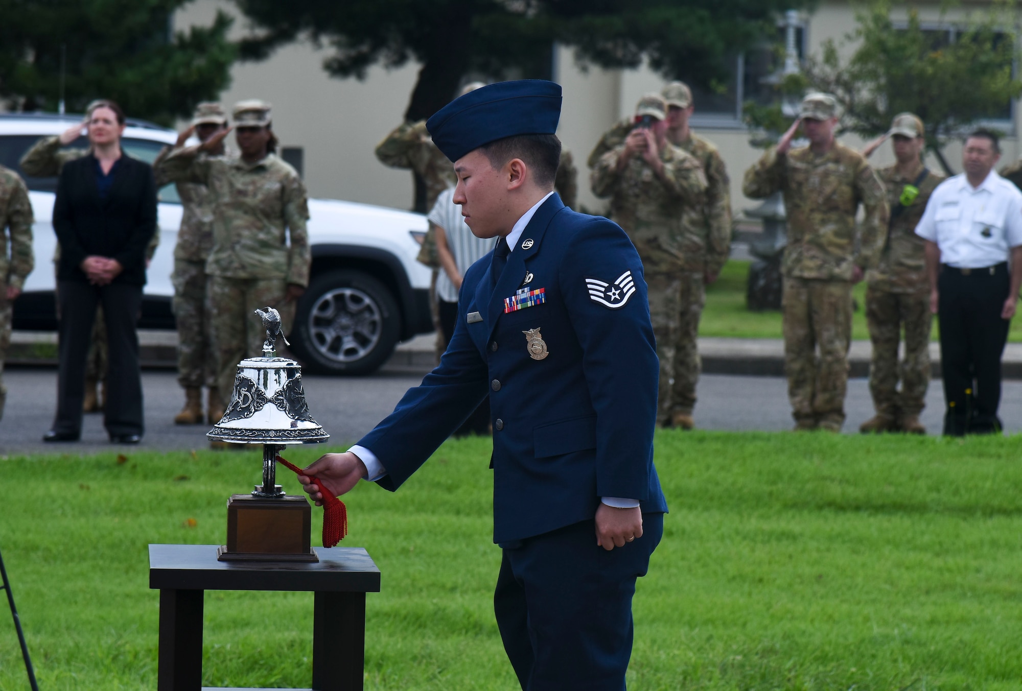 A military member rings a bell.