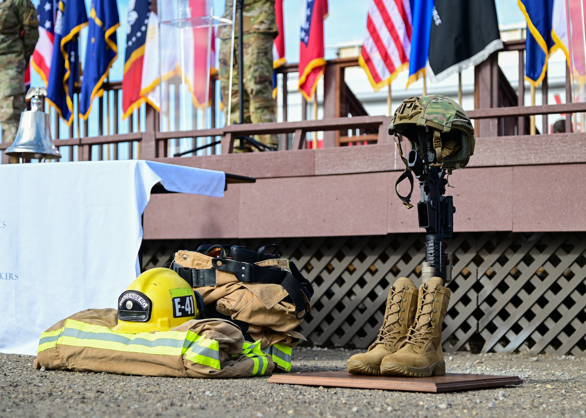 An arrangement of first responders and military gear is displayed during a ceremony.