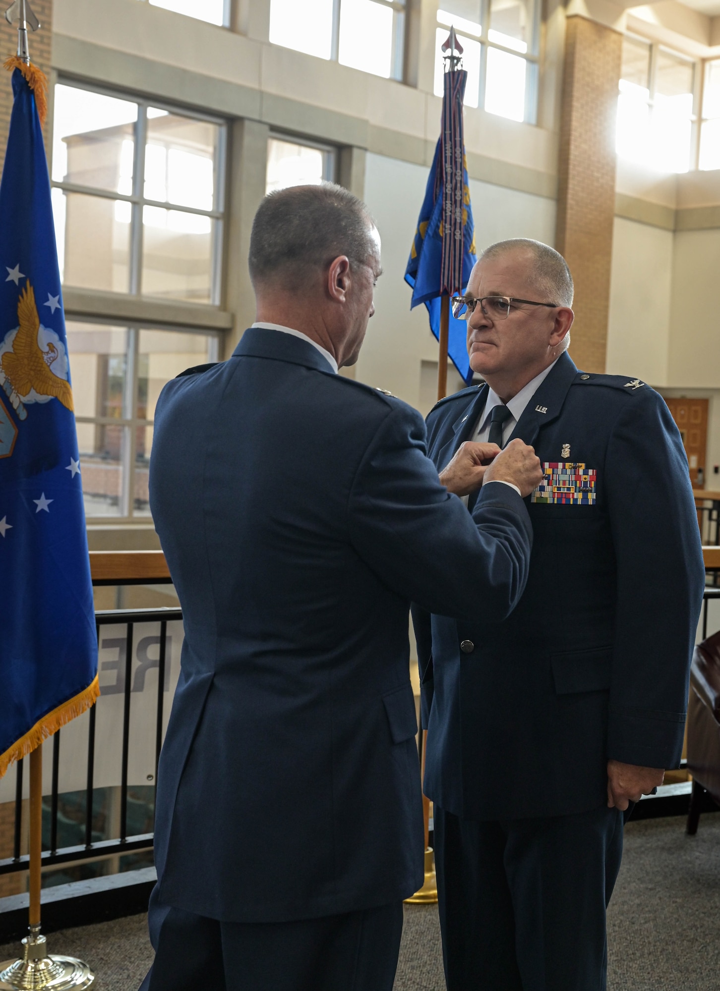 a man pins an award on another man