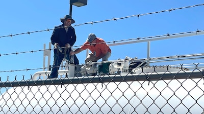 two men on top of a fuel tank