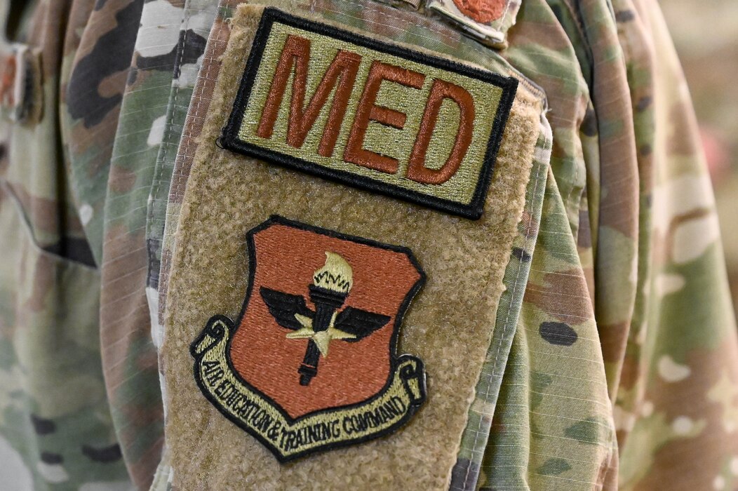 An Airman of the 97th Medical Group wears an Air Education and Training Command (AETC) and medical occupation patch at Altus Air Force Base Oklahoma, Sept. 13, 2023. AETC’s senior medical leadership team visited the 97th Medical Group to witness the medical clinic’s current programs and readiness capabilities. (U.S. Air Force photo by Airman 1st Class Heidi Bucins)