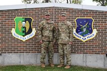 U.S. Air Force Col. Benjamin Jensen, 5th Bomb Wing deputy commander (left), and U.S. Air Force Col. George Chapman, 91st Missile Wing deputy commander, pose for a photo next to their respective wing’s shield at Minot Air Force Base, North Dakota, Sept. 11, 2023. Jensen and Chapman are Minot Air Force Base’s newest, and first ever, deputy commanders. (U.S. Air Force photo by Airman 1st Class Kyle Wilson)