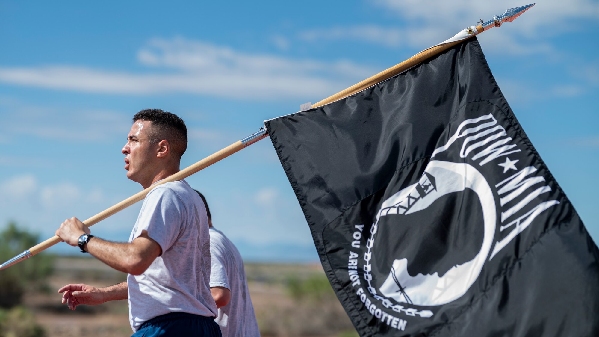 U.S. Air Force Senior Airman Mehdi Mounib, 49th Logistics Readiness Squadron inventory journeyman, with POW/MIA flag during POW/MIA Recognition Day at Holloman Air Force Base, New Mexico, Sept. 14, 2023.