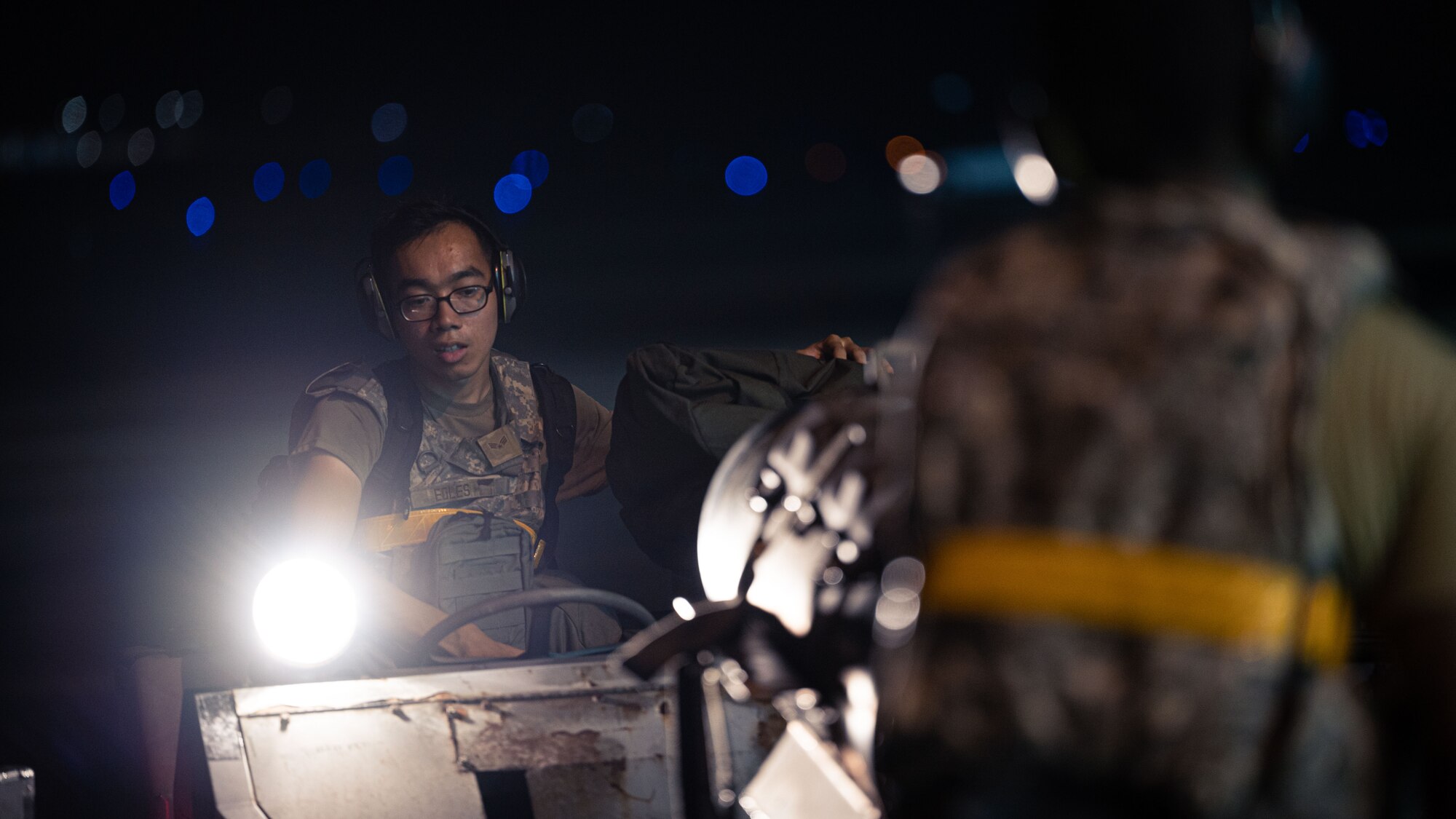 Airman 1st Class Shawn Edles uses a loader vehicle to move munitions while preparing an F-16 Fighting Falcon for flight operations.