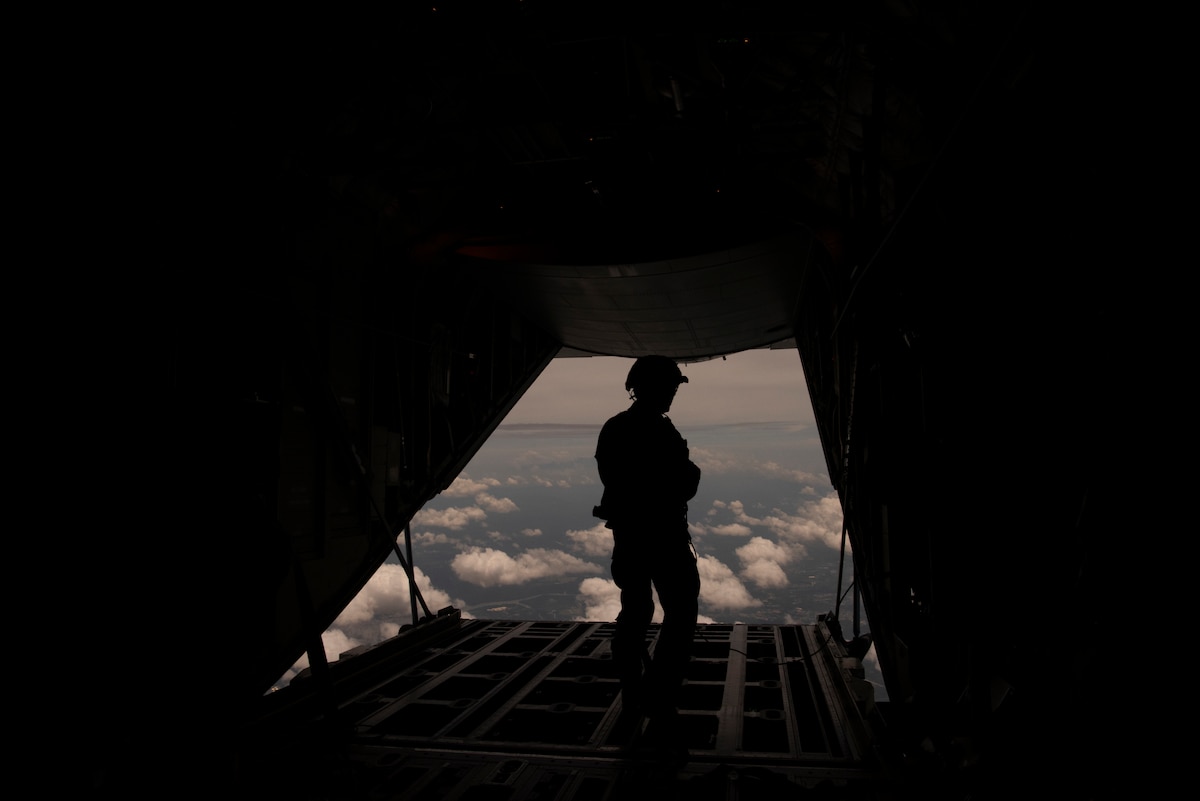 Photo of a service members silhouette in the back of an aircraft