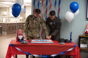 U.S. Air Force Col. Scott Mills, 355th Wing commander, and Airman 1st Class Caleb Jacks, 79th Rescue Squadron crew chief, cut a cake in the Desert Inn Dining Facility at Davis-Monthan Air Force Base, Ariz., Sept. 18, 2023. The cake was cut by the commander and the youngest Airman, symbolizing the experience and the future of the Air Force. (U.S. Air Force photo by Airman 1st Class Robert Allen Cooke III)