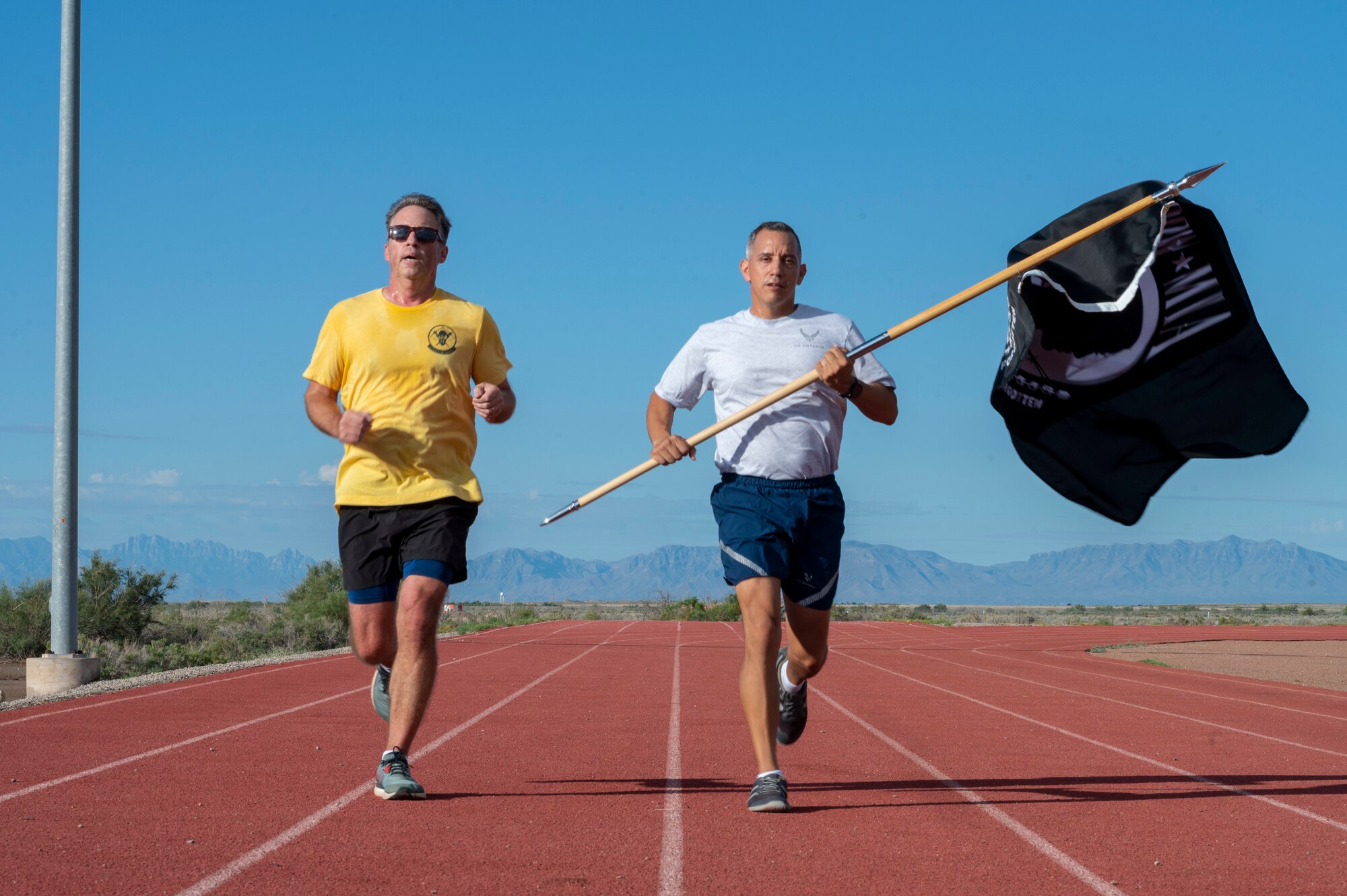 U.S. Air Force Col. Alfred Rosales, 49th Wing deputy commander, right, runs in honor of POW/MIA service members with Daniel Cass, 49th Wing chief of staff, during POW/MIA Recognition Day at Holloman Air Force Base, New Mexico, Sept. 14, 2023.