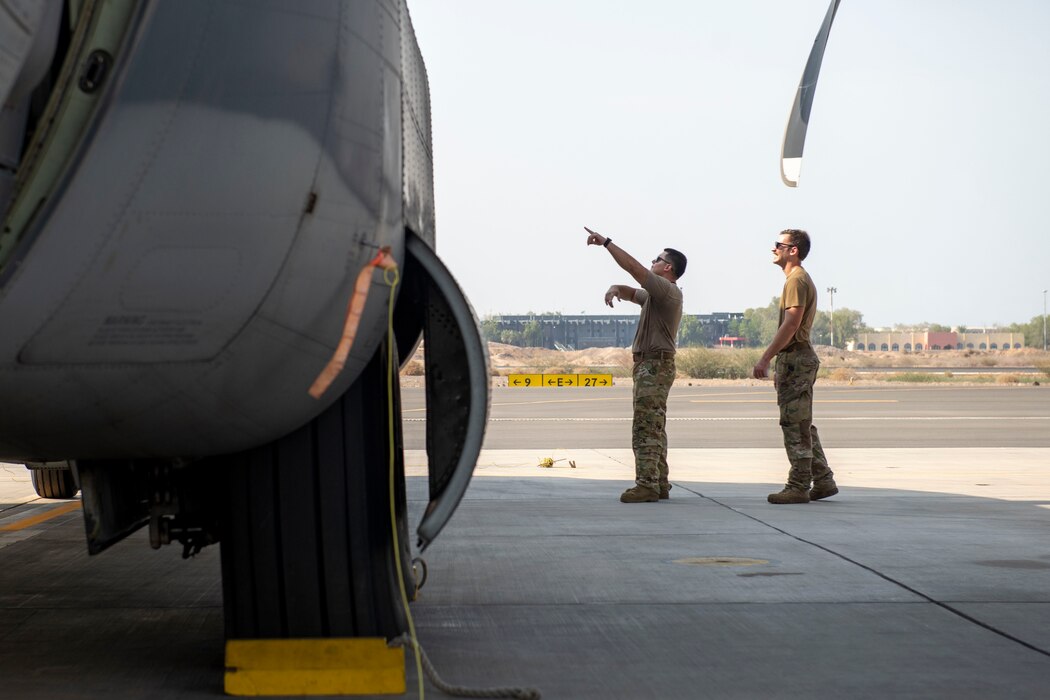 Photo of two men pointing at an aircraft