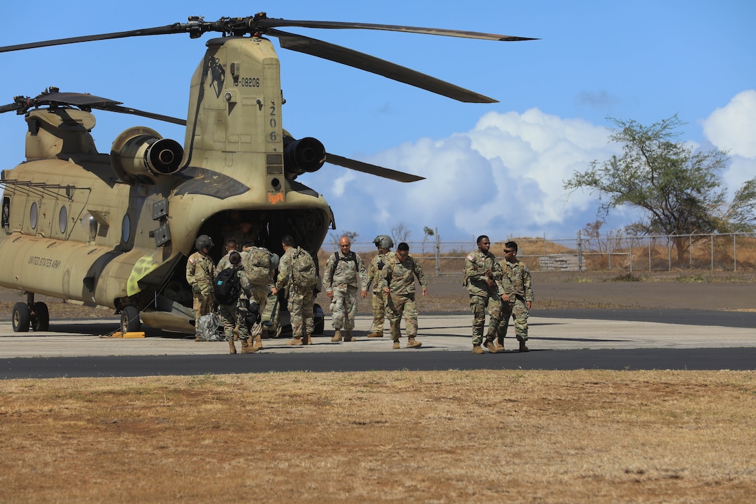 Soldiers disembark from a Boeing CH-47 Chinook.