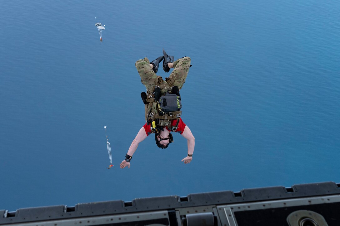 An airman jumps out of an airplane.