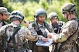 Staff Sgt. Melissa Haley, U.S. Army Reserve paralegal noncommissioned officer of the 154th Legal Operations Detachment (Trial Defense Services), is pictured strategizing with her squad leaders an avenue of approach to clear their first objective during the Paralegal Warrior Training Course (PWTC) on July 25, 2023.