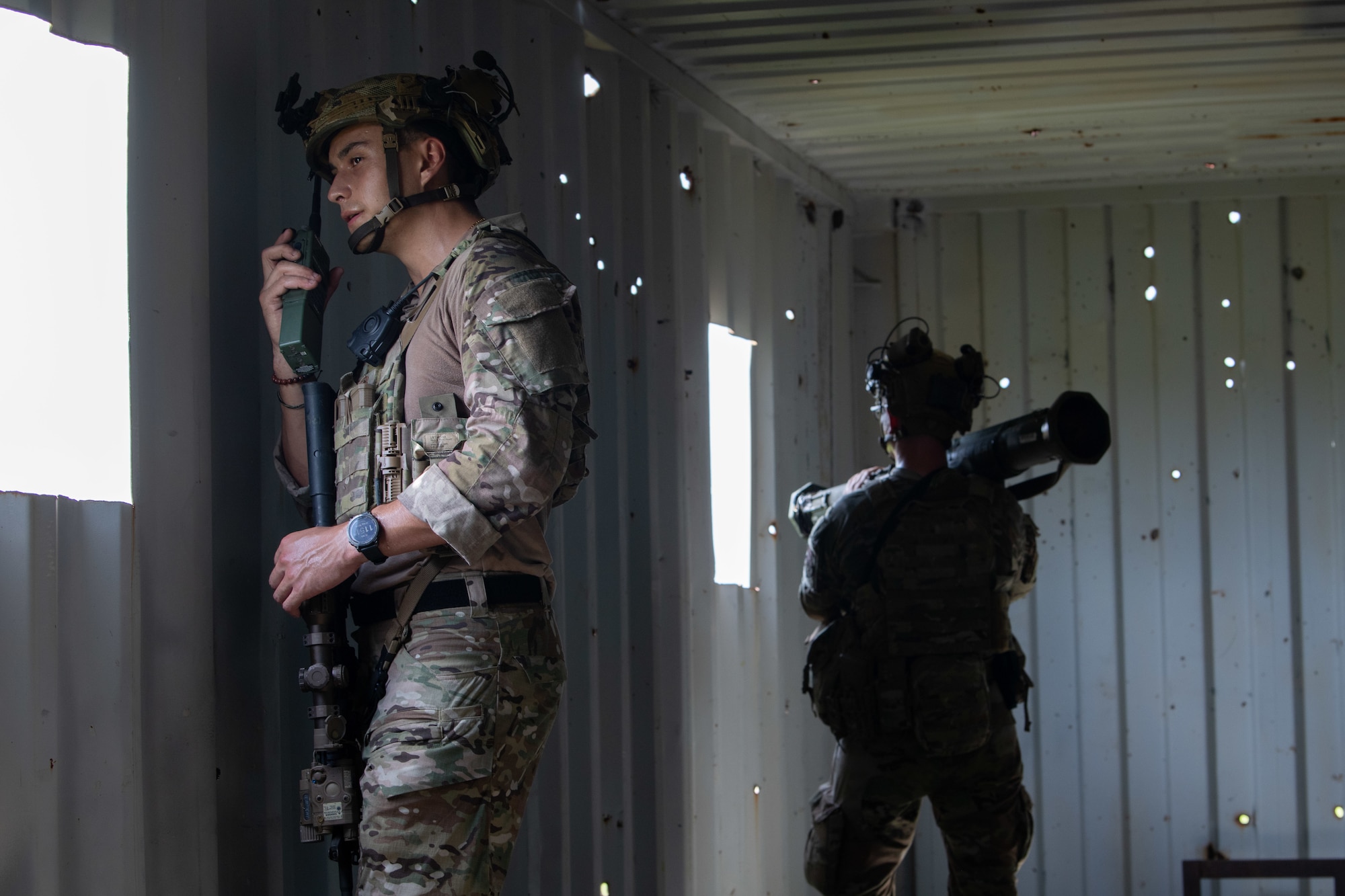 U.S. Air Force Airmen from the 824th Base Defense Squadron talk on a radio and defend a contingency location at Avon Park Air Force Range, Florida, August 22, 2023. 824th BDS Airmen proved they were ready to provide security and support for upcoming Lead Wing operations through their mission readiness exercise. (U.S. Air Force photo by 1st Lt. Christian Little)