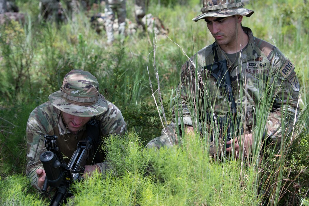 Two U.S. Air Force Airmen from the 824th Base Defense Squadron perform weapons maintenance on a machine gun at a defensive fighting position at Avon Park Air Force Range, Florida, August 22, 2023. 824th BDS uses machine guns to provide increased security and defense of operating locations. 824th BDS Airmen proved they were ready to provide security and support for upcoming Lead Wing operations through their mission readiness exercise. (U.S. Air Force photo by 1st Lt. Christian Little)