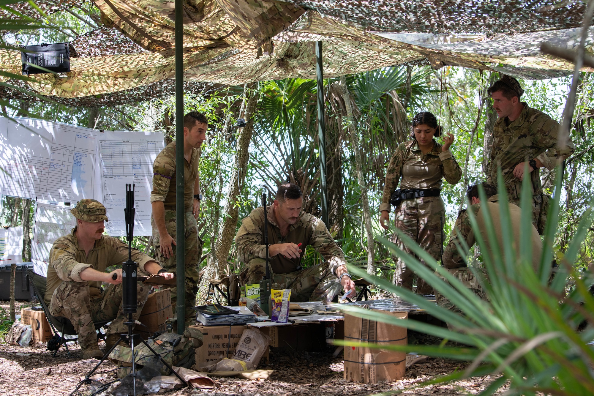 U.S. Air Force Airmen from the 824th Base Defense Squadron discuss operations in a tactical operations center at Avon Park Air Force Range, Florida, August 22, 2023. This headquarters element provided command and control of defensive forces for a forward operating site and two contingency locations. 824th BDS Airmen proved they were ready to provide security and support for upcoming Lead Wing operations through their mission readiness exercise. (U.S. Air Force photo by 1st Lt. Christian Little)