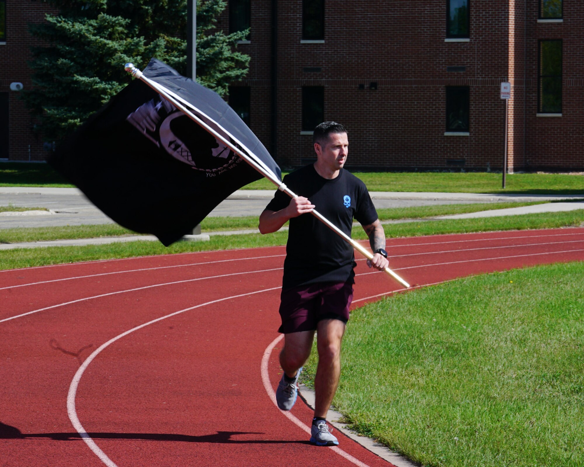 Airman running with the POW/MIA flag.