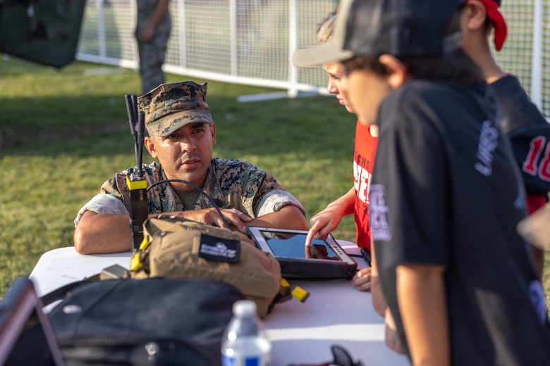 U.S. Marine Corps Gunnery Sgt. Paul I. Padilla, an explosive ordnance disposal technician with Marine Wing Support Squadron 372, Marine Aircraft Group 39, 3rd Marine Aircraft Wing, supervises students using the 310 Small Unmanned Ground Vehicle robot tablet during San Clemente High School’s military appreciation day at Thalassa Stadium, San Clemente, California, Sept. 8, 2023.   Padilla demonstrated the equipment used by EOD Marines to locate, neutralize, and dispose of hazards with remote control robots and a bomb suit to students and parents of San Clemente High School.   (U.S. Marine Corps photo by Lance Cpl. Jennifer Sanchez)