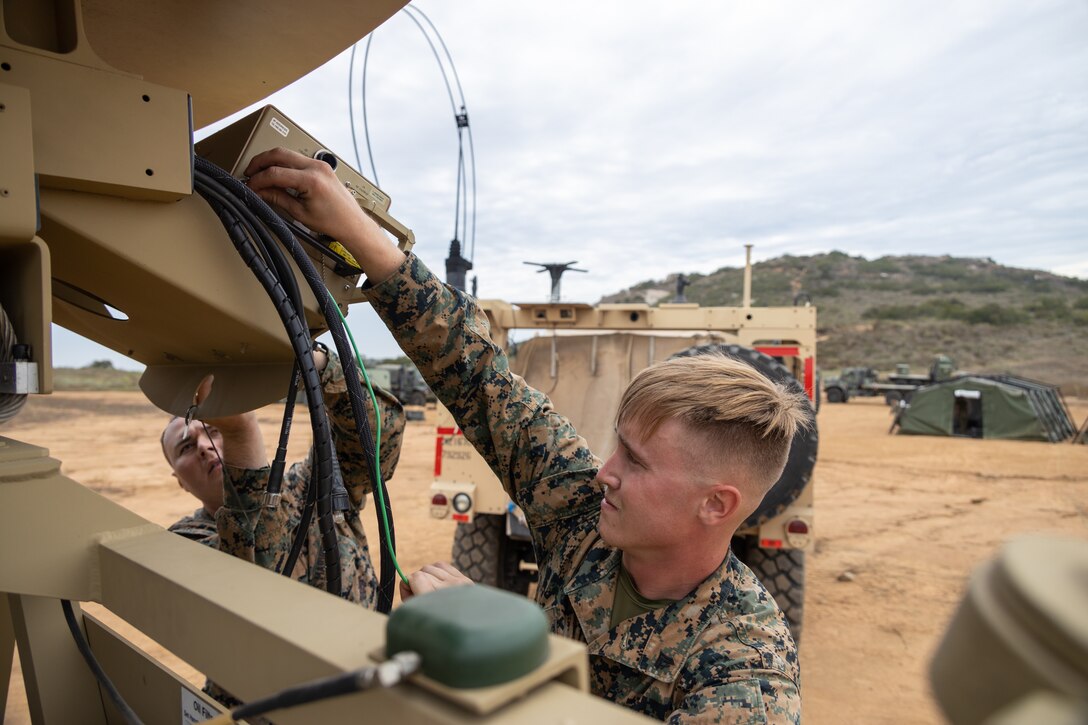U.S. Marine Corps Cpl. Clinton Mott, left, and Cpl. Wyatt Szulewski, both wideband satellite communication operators with 9th Communication Battalion, I Marine Expeditionary Force Information Group, setup a satellite communication subsystem during the I MIG Command Post Exercise on Marine Corps Base Camp Pendleton, California, Sept. 11, 2023. The I MIG CPX allows the force to balance future and current expeditionary operations utilizing the authorization to operate cycle in order to conduct, shape and sustain operations as directed by I MEF. (U.S. Marine Corps photo by Sgt. Anabel Abreu Rodriguez)