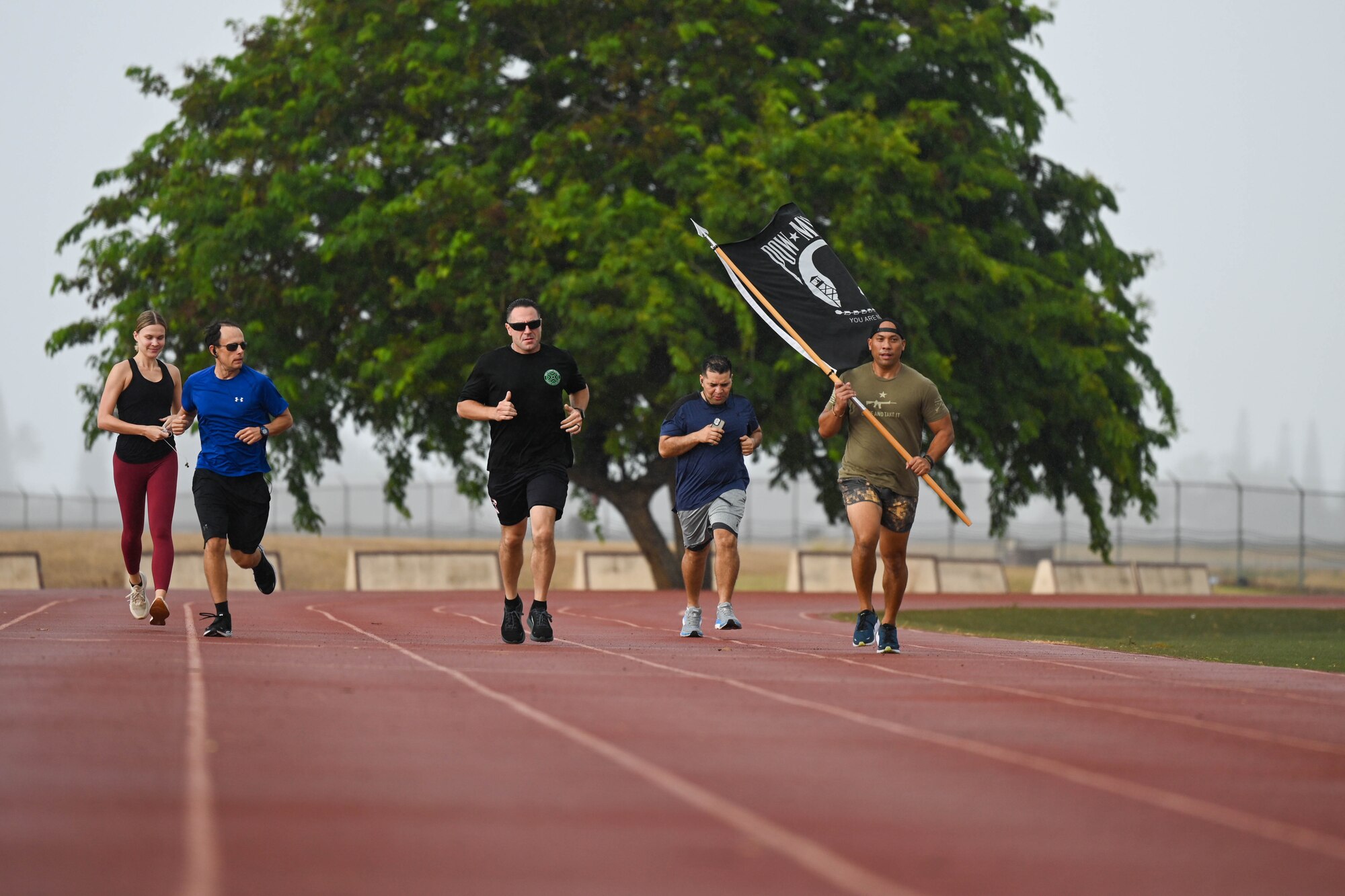 Hickam Airmen honor U.S. service members who were prisoners of war and are missing in action by running with a Prisoner of War and Missing in Action flag at Joint Base Pearl Harbor-Hickam, Hawaii, September 14, 2023. POW/MIA remembrance day formally became a national observance in 1979 to honor more than 81,000 Americans who are still missing in action. (U.S. Air Force photo by Senior Airman Makensie Cooper)