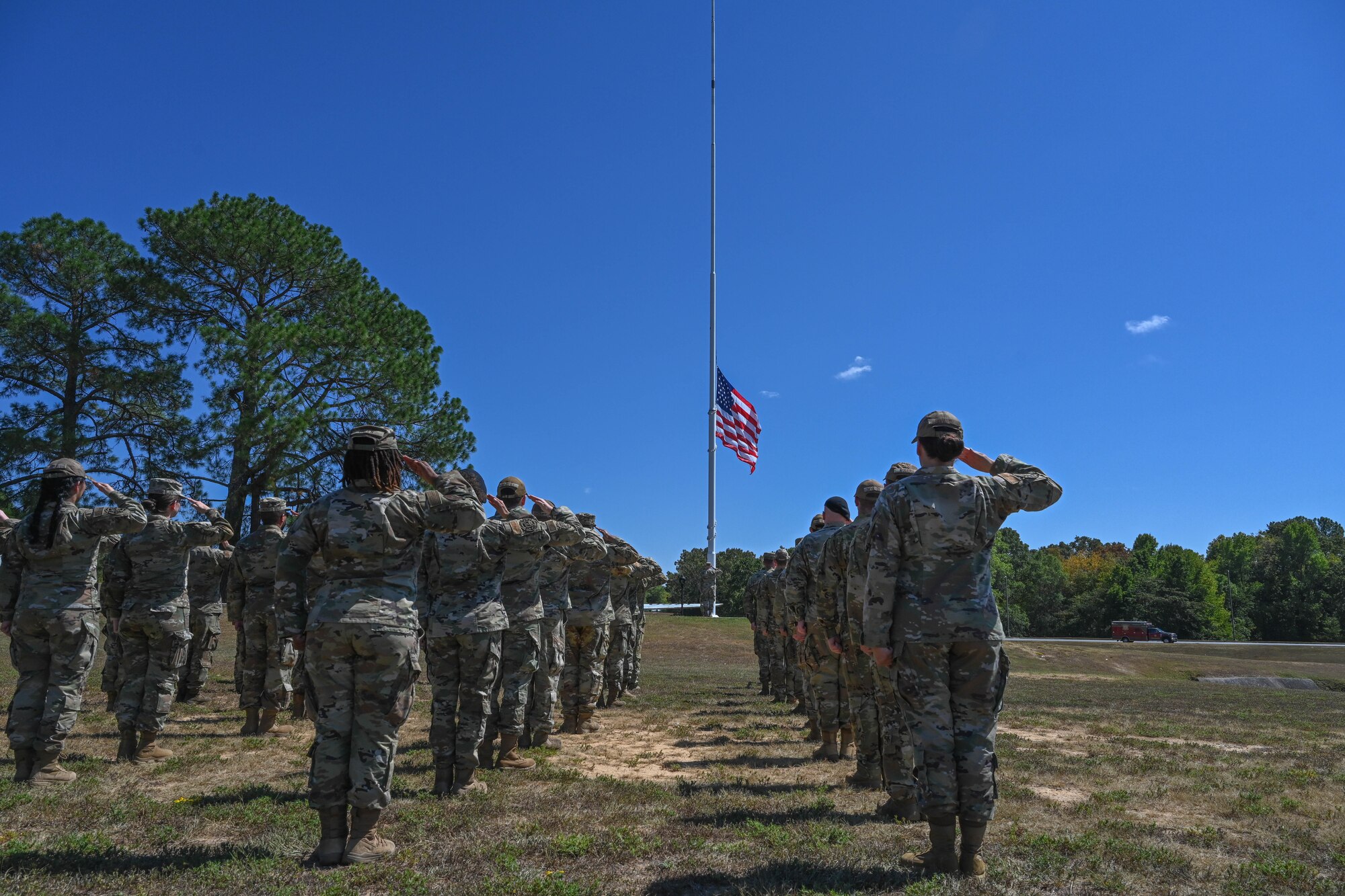 Airmen salute a flag in formation.