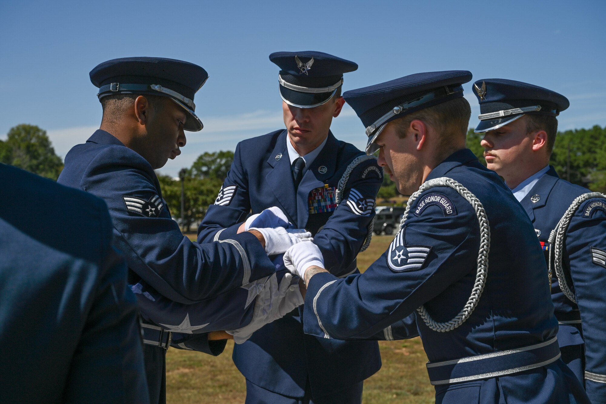 Honor guard members fold a flag.