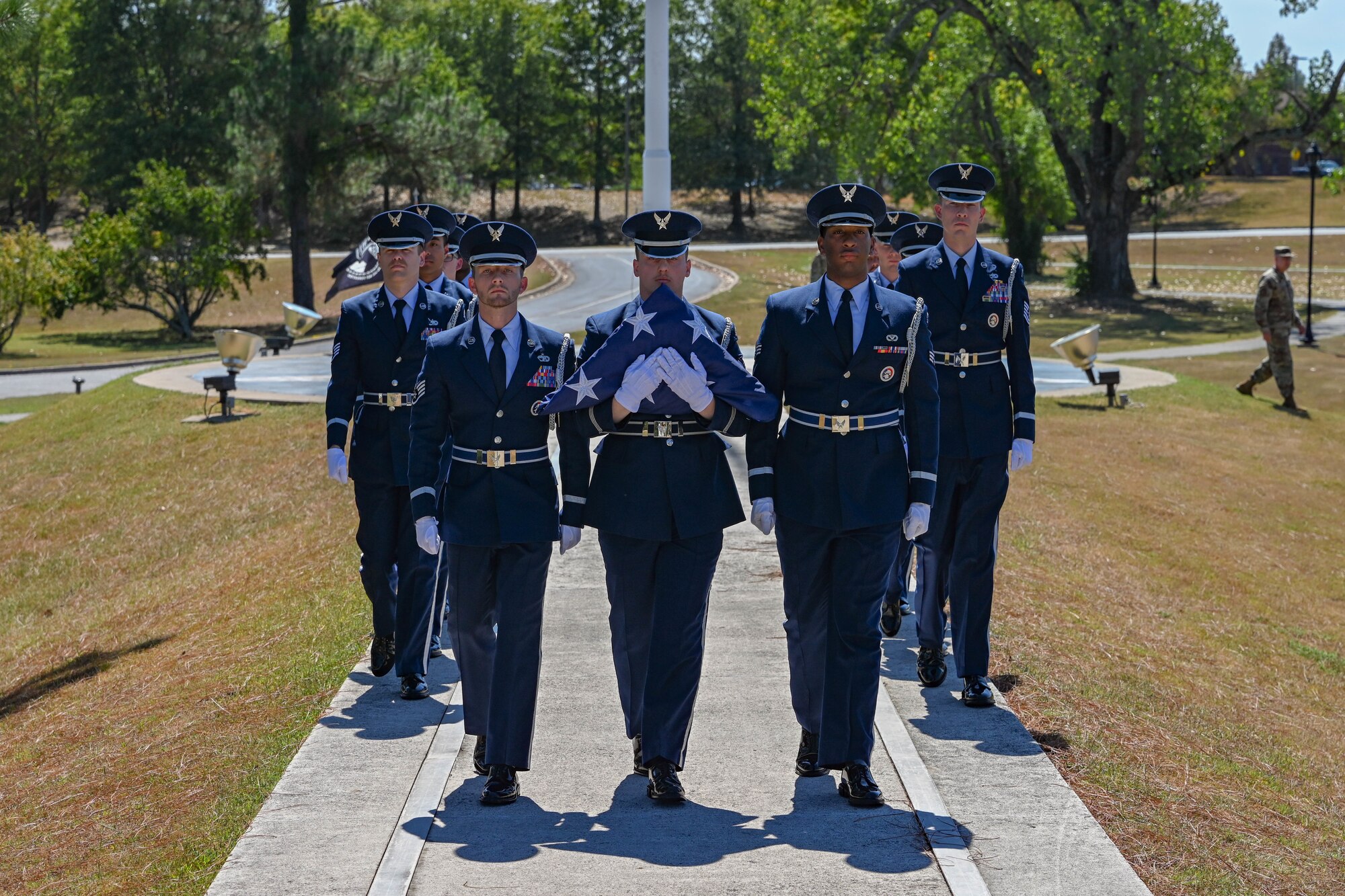 Honor guard members hold a folded flag.