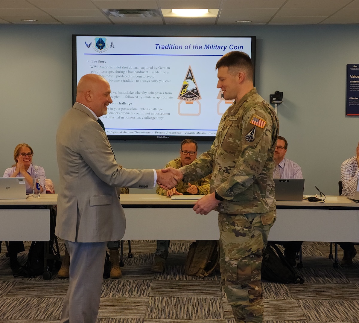 Lt. Col. William Dexter, chief, Space Safety Issues, being coined by Dr. Mark Glissman, chief, AFSEC Space Safety division and SpSC Chair, at the Space Safety Council. The Space Safety Council meets twice a year to discuss items pertinent to the development of Space policy, mishap prevention & investigations, and implementation of the Air Force Safety Management System. (Courtesy Photo)