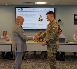 Lt. Col. William Dexter, chief, Space Safety Issues, being coined by Dr. Mark Glissman, chief, AFSEC Space Safety division and SpSC Chair, at the Space Safety Council. The Space Safety Council meets twice a year to discuss items pertinent to the development of Space policy, mishap prevention & investigations, and implementation of the Air Force Safety Management System. (Courtesy Photo)