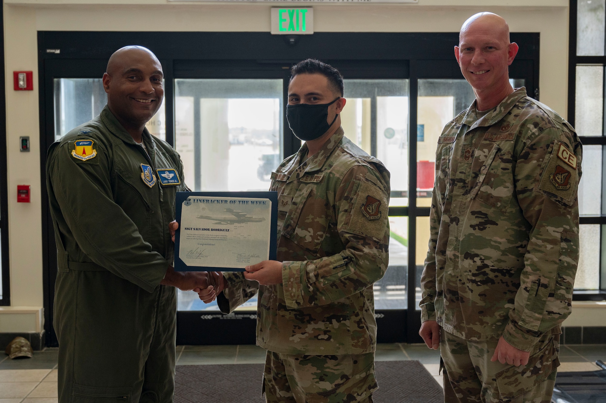 U.S. Air Force Staff Sgt. Salvador Rodriguez, the group training manager assigned to the 36th Medical Group, receives the Linebacker of the Week Award from U.S. Air Force Col. Larry Fenner, vice commander of the 36th Wing, and U.S. Air Force Chief Master Sgt. Donald McNair, the senior enlisted leader of the 36th Civil Engineering Squadron, at Andersen Air Force Base, Guam, Sept. 13, 2023. The Team Andersen Linebacker of the Week recognizes outstanding enlisted, officer, civilian and total force personnel who have had an impact on achieving Team Andersen’s mission, vision and priorities. (U.S. Air Force photo by Airman 1st Class Emily Saxton)