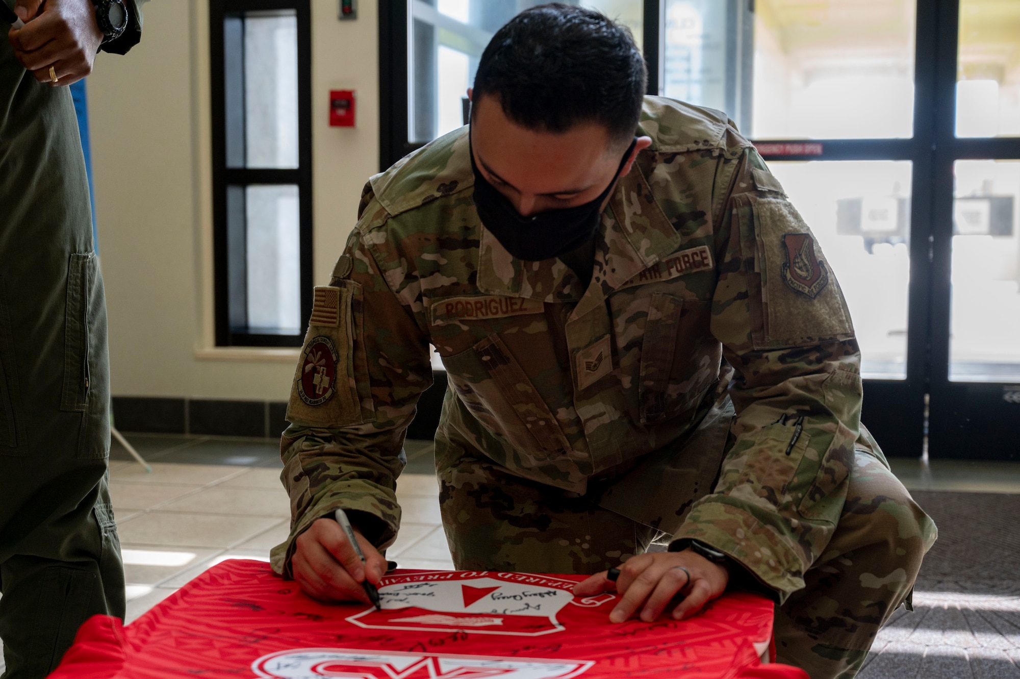 U.S. Air Force Staff Sgt. Salvador Rodriguez, the group training manager assigned to the 36th Medical Group, signs the Linebacker of the Week jersey at Andersen Air Force Base, Guam, Sept. 13, 2023. The Team Andersen Linebacker of the Week recognizes outstanding enlisted, officer, civilian and total force personnel who have had an impact on achieving Team Andersen’s mission, vision and priorities. (U.S. Air Force photo by Airman 1st Class Emily Saxton)