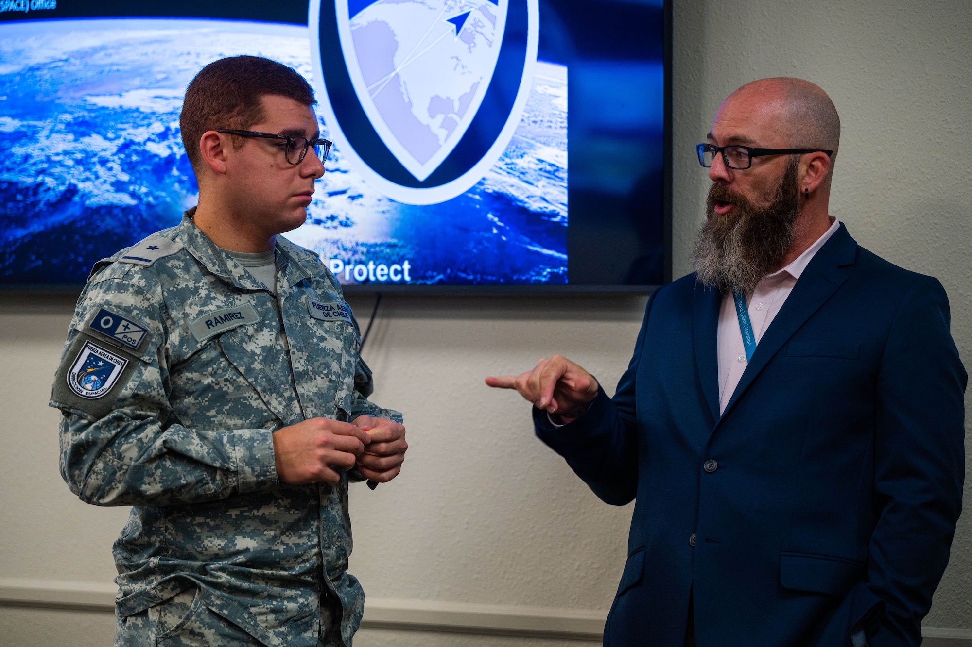 Chilean Air Force 2nd Lt. Matias Ramirez Cisternas, Space Operations Group member, left, and Donny Gollihar, Combined Force Space Component Command Strategic Engagements Division lead associate, right, interact during the Chilean Air Force visit to the 18th Space Defense Squadron on Vandenberg Space Force Base, Calif., Sept. 14, 2023. The Combined Force Space Component Command hosted a delegation from partner nation Chile with discussions focused on Space Domain Awareness, aiming to increase the understanding and benefits of existing Space Situational Awareness sharing agreements, interoperability, and integration (U.S. Space Force photo by Tech. Sgt. Luke Kitterman)