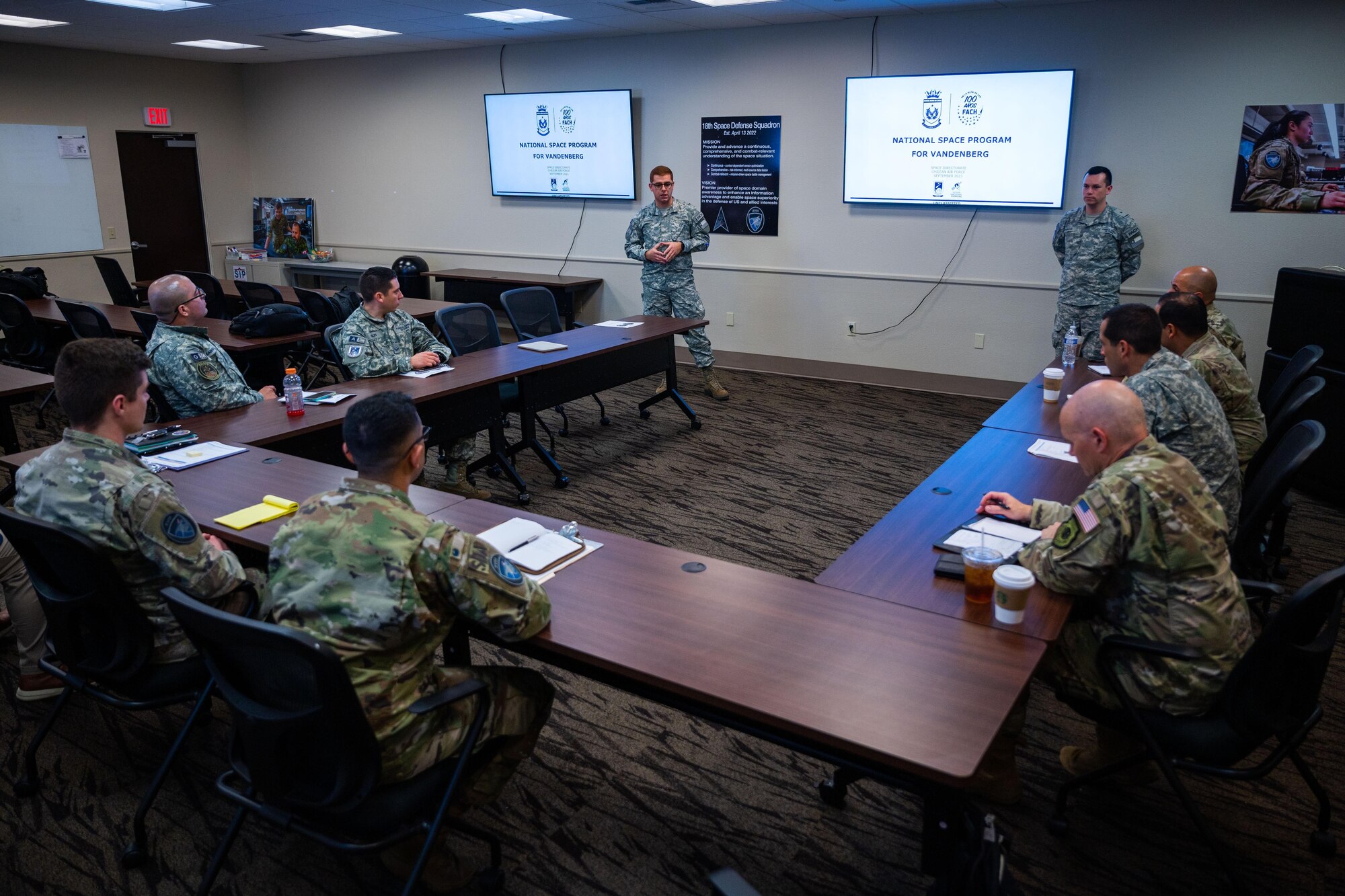 Two members of the Chilean Air Force give a presentation on Chilean space capabilities and organizational structure to members of the 18th Space Defense Squadron and U.S. Southern Command during their immersion on Vandenberg Space Force Base, Calif., Sept. 14, 2023. The Combined Force Space Component Command hosted a delegation from partner nation Chile with discussions focused on Space Domain Awareness, aiming to increase the understanding and benefits of existing Space Situational Awareness sharing agreements, interoperability, and integration (U.S. Space Force photo by Tech. Sgt. Luke Kitterman)