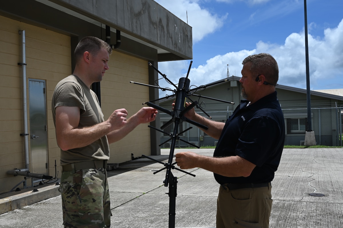 two men set up a communications antenna