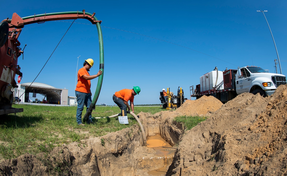 Construction workers create a path for electrical cables Sept. 19 at Eglin Air Force Base, Florida.  The electrical cables will connect to the DOD’s first ever electric aircraft charging station.  (U.S. Air Force photo/Samuel King Jr.)