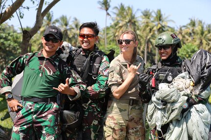 Four people in military uniforms pose for a photo.