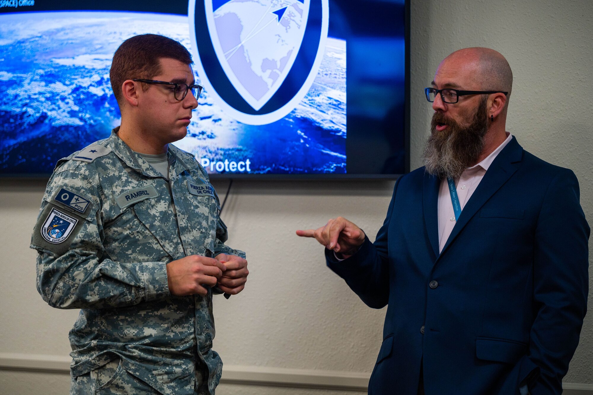 Chilean Air Force 2nd Lt. Matias Ramirez Cisternas, Space Operations Group member, left, and Donny Gollihar, Combined Force Space Component Command Strategic Engagements Division lead associate, right, interact during the Chilean Air Force visit to the 18th Space Defense Squadron on Vandenberg Space Force Base, Calif., Sept. 14, 2023. The Combined Force Space Component Command hosted a delegation from partner nation Chile with discussions focused on Space Domain Awareness, aiming to increase the understanding and benefits of existing Space Situational Awareness sharing agreements, interoperability, and integration (U.S. Space Force photo by Tech. Sgt. Luke Kitterman)