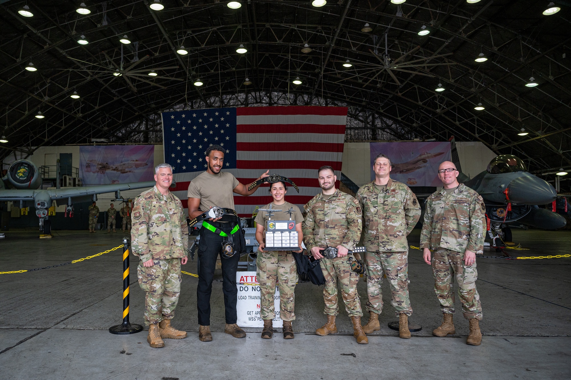 25th Fighter Generation Squadron weapons load crew members pose for a group photo after winning a quarterly load crew competition at Osan Air Base, Republic of Korea, Sept. 15, 2023. These competitions occur quarterly, which is crucial for regularly assessing and improving Airmen's readiness and performance, ensuring a consistently high level of operational superiority and excellence throughout the year. (U.S. Air Force photo by Staff Sgt. Thomas Sjoberg)