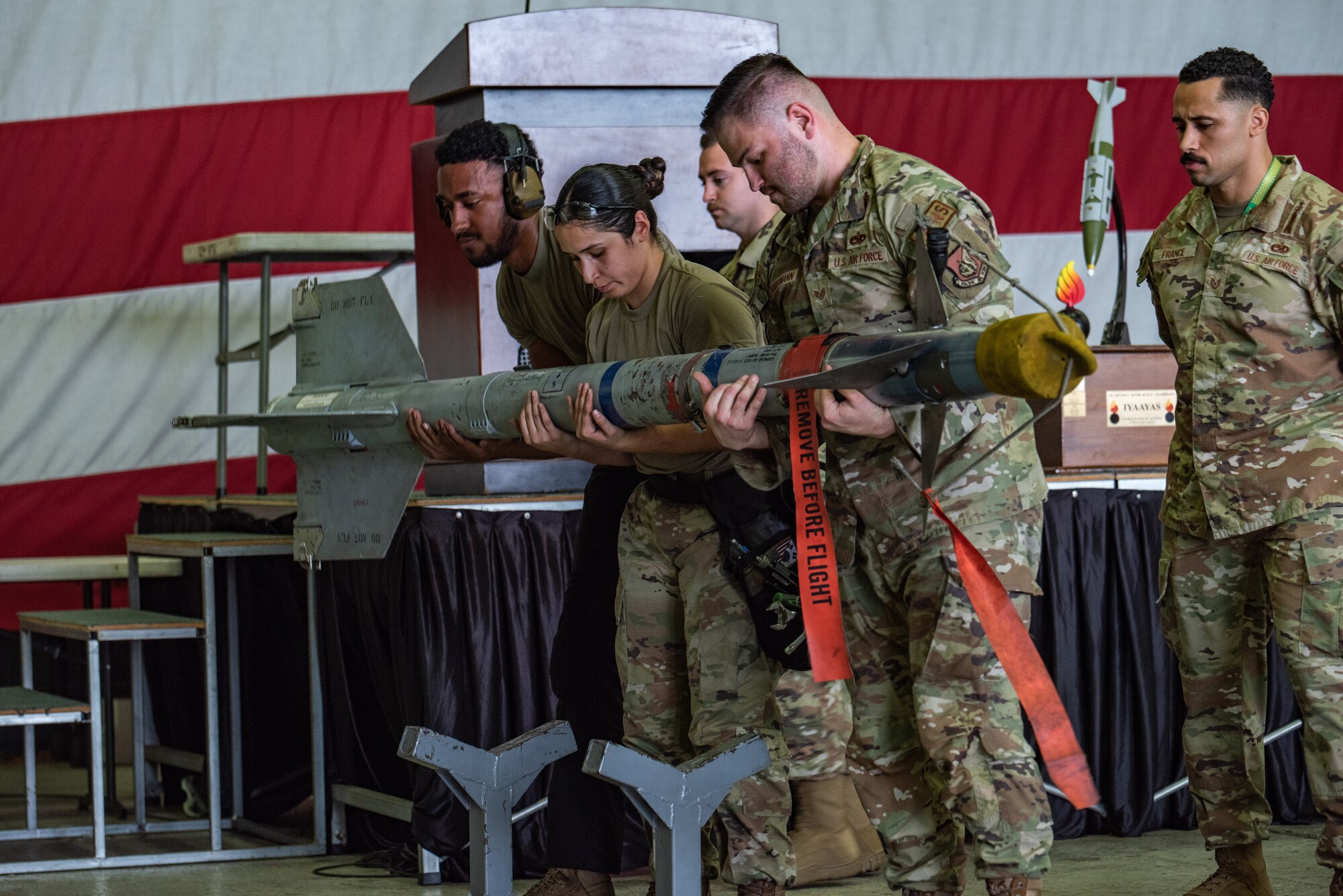 A 25th Fighter Generation Squadron load crew team lifts an AIM-9L/M Sidewinder to be loaded on an A-10C Thunderbolt II during a quarterly load crew competition at Osan Air Base, Republic of Korea, Sept. 15, 2023. Three-member teams from the 25th and the 36th FGS competed against each other to showcase their weapon loading capabilities and mission readiness. (U.S. Air Force photo by Airman 1st Class Chase Verzaal)