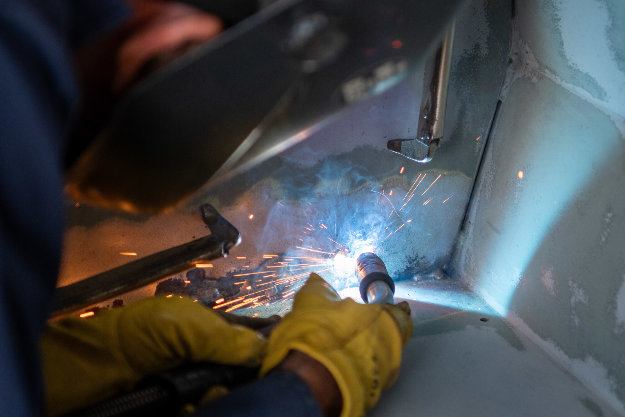 A welder conducts corrosion repairs.