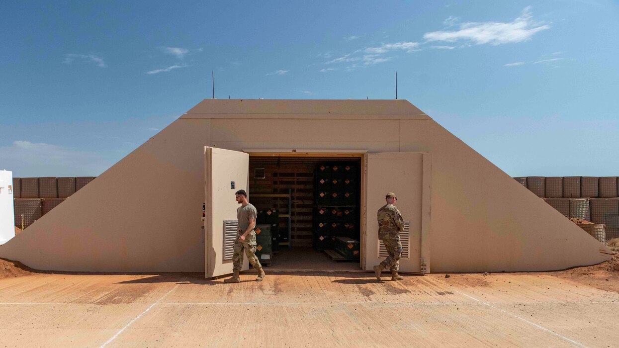 Photo of two men closing the doors of a storage bunker