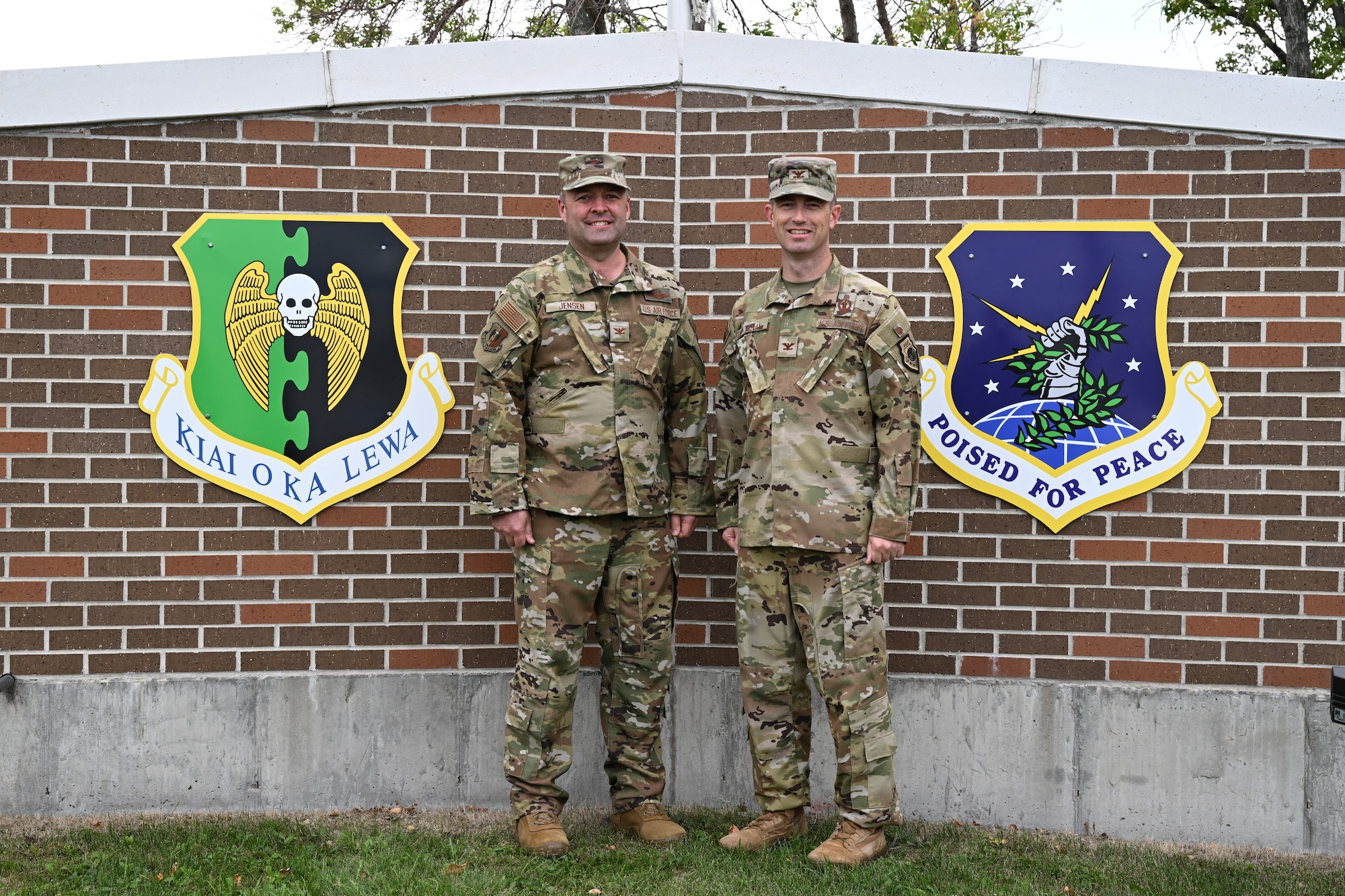 U.S. Air Force Col. Benjamin Jensen, 5th Bomb Wing deputy commander (left), and U.S. Air Force Col. George L. Chapman, 91st Missile Wing deputy commander, pose for a photo next to their respective wing’s shield at Minot Air Force Base, North Dakota, Sept. 11, 2023. Jensen and Chapman are Minot Air Force Base’s newest deputy commanders. (U.S. Air Force photo by Airman 1st Class Kyle Wilson)