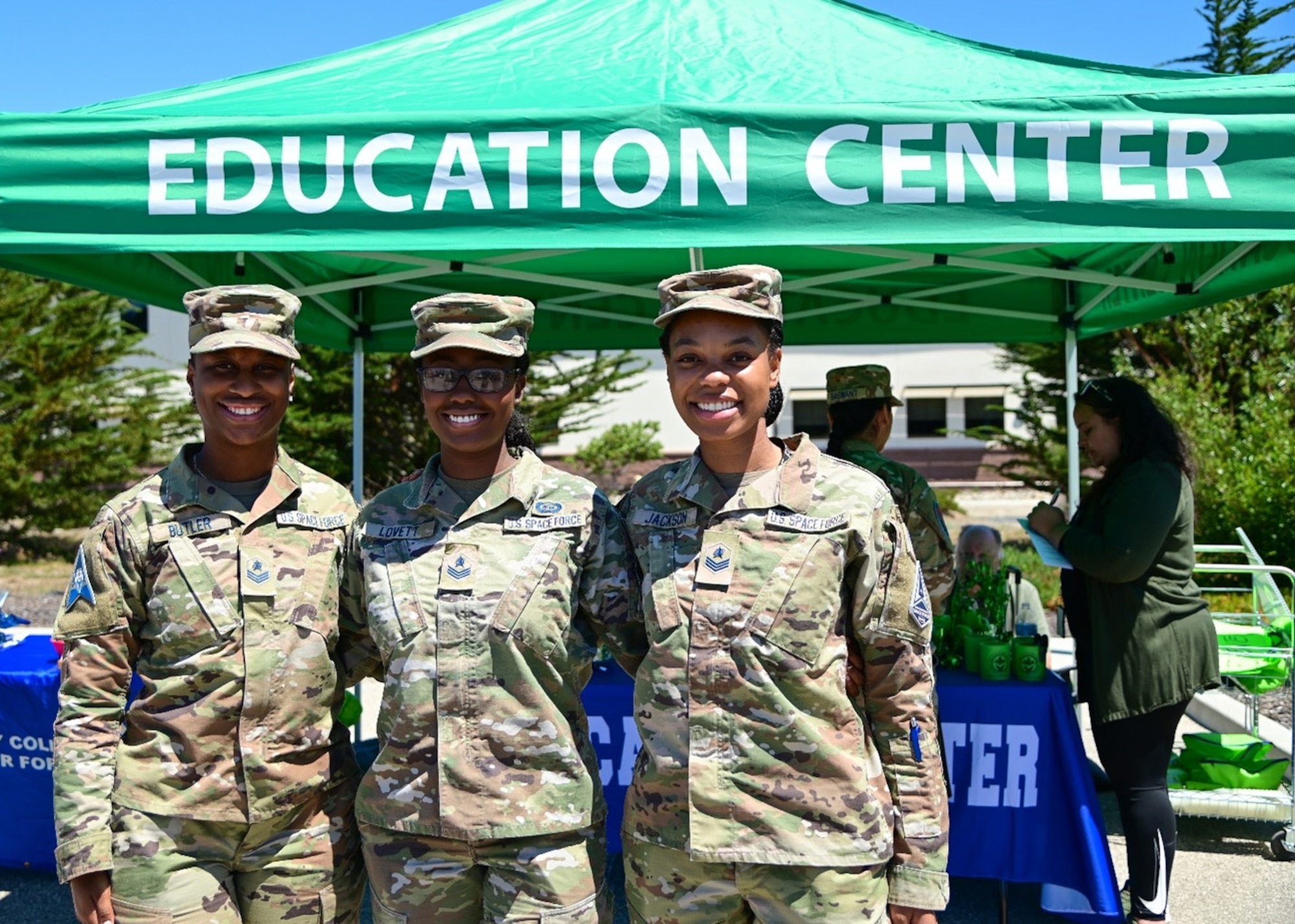 Three women in uniform pose for a picture.