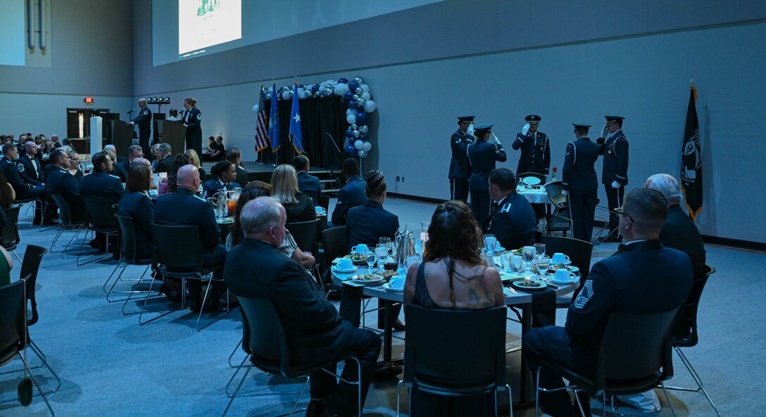 Ellsworth Air Force Base Honor Guard members render a salute to the round table reserved for POW/MIA members, during the Air Force Ball, Sept. 16, 2023, in Box Elder, South Dakota.